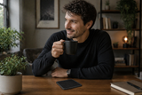 Man holding a black mug in a cozy indoor setting